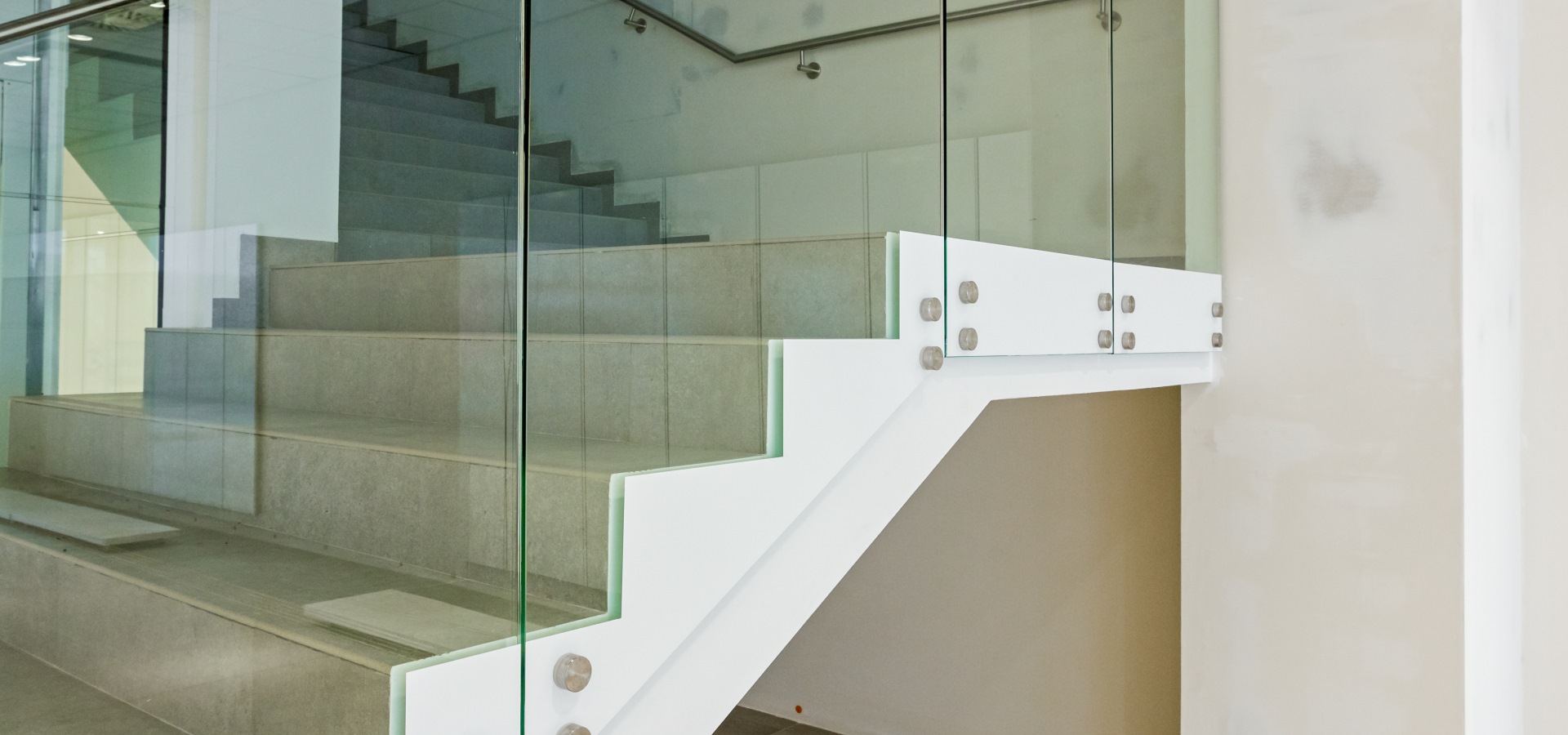 Detail on stairway with glass railing in a new modern building.